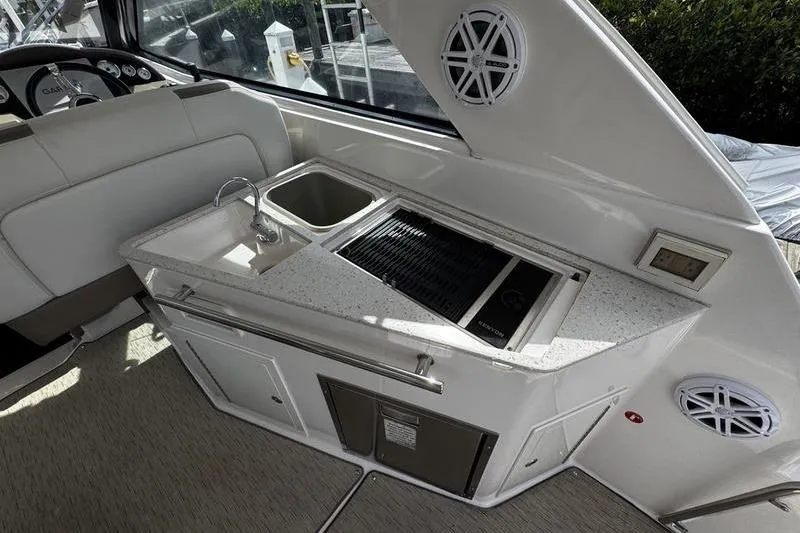 Slide: The Image of 2018 Regal 35 Sport Coupe boat interior with kitchenette, sink, and grill. - 19
