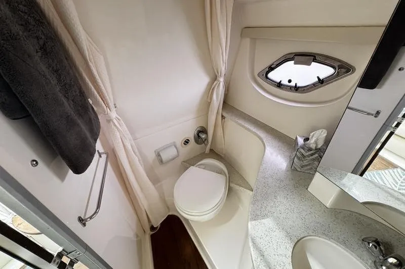 Slide: The Image of 2018 Regal 35 Sport Coupe bathroom with toilet, sink, and porthole window. - 44