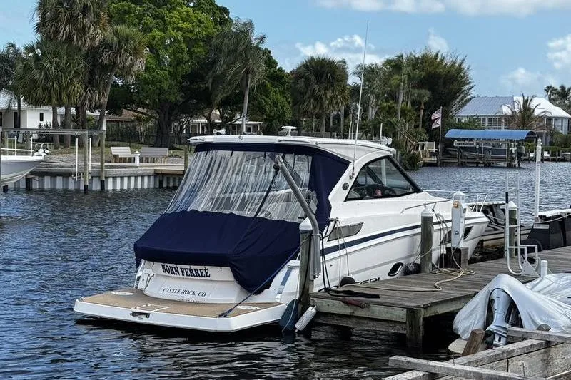 Slide: The Image of 2018 Regal 35 Sport Coupe docked by a scenic waterfront with lush greenery. - 5
