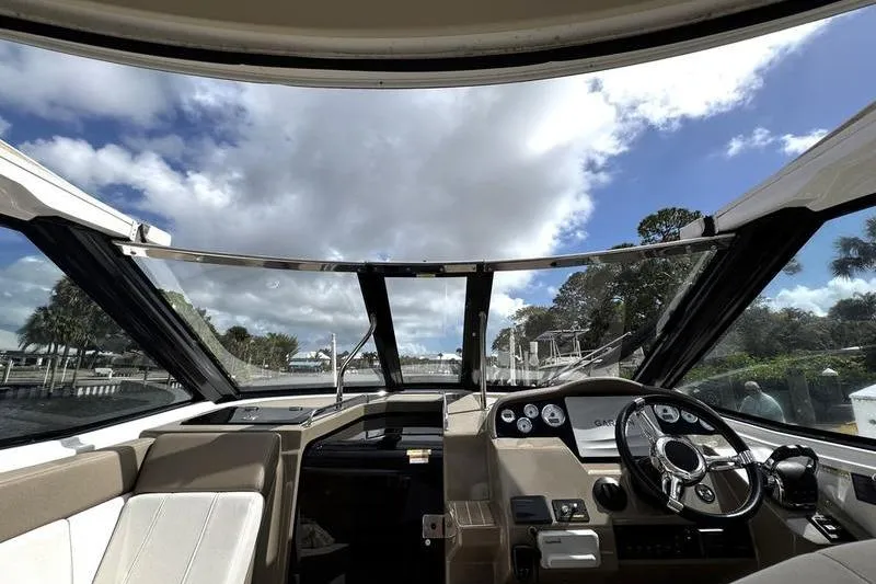 Slide: The Image of Interior view of 2018 Regal 35 Sport Coupe boat cockpit under a partly cloudy sky. - 50