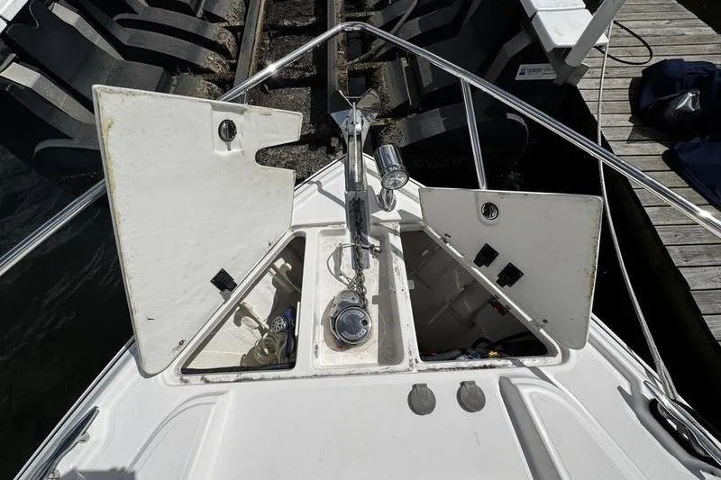 Slide: The Image of 2018 Regal 35 Sport Coupe boat anchor compartment with open hatches at dock. - 52