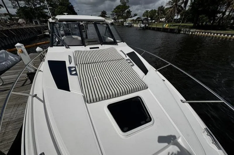 Slide: The Image of 2018 Regal 35 Sport Coupe boat docked, featuring sleek design and spacious deck. - 55