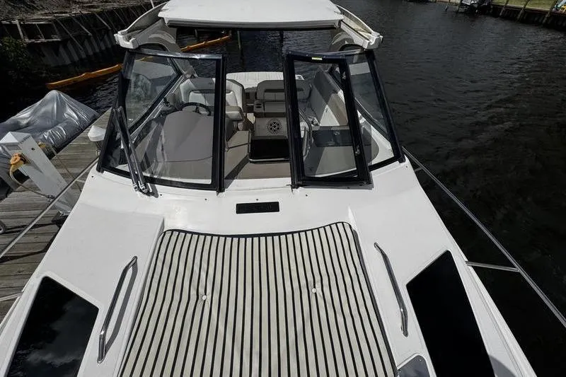 Slide: The Image of 2018 Regal 35 Sport Coupe boat with open cockpit, docked by the water. - 57