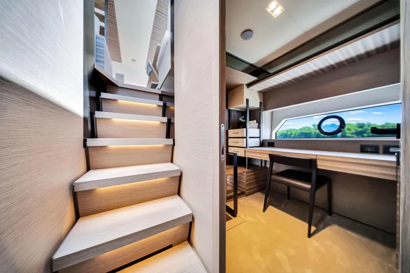 Slide: The Image of Luxurious interior of 2022 Ferretti Yachts 670, featuring elegant stairs and a modern workspace. - 38