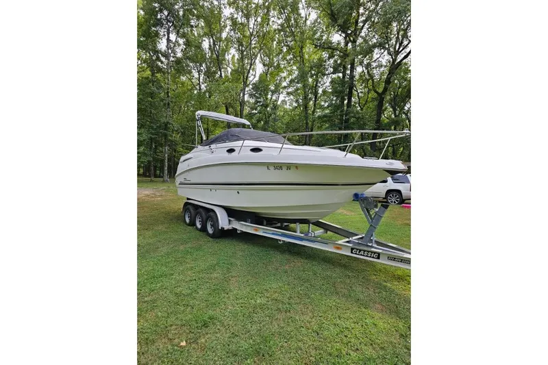 The Image of 2002 Chaparral Signature 240 boat on trailer, parked on grass with trees in background. - 1