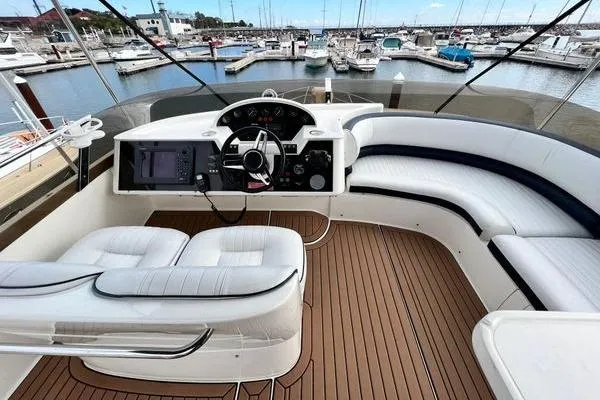 Slide: The Image of 2003 Viking Princess 50 Sport Cruiser helm with luxurious seating and marina view. - 10