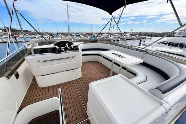 Slide: The Image of 2003 Viking Princess 50 Sport Cruiser with spacious deck and seating in marina setting. - 11