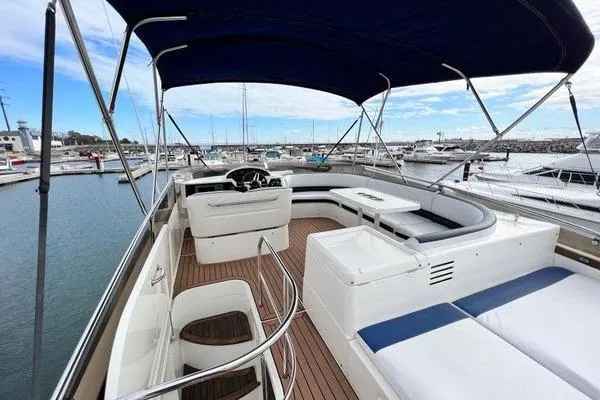 Slide: The Image of 2003 Viking Princess 50 Sport Cruiser with spacious deck and seating, docked at marina. - 12