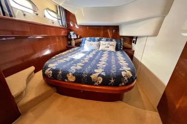 Slide: The Image of Luxurious cabin interior of 2003 Viking Princess 50 Sport Cruiser with nautical-themed bedding. - 18