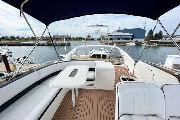 Slide: The Image of 2003 Viking Princess 50 Sport Cruiser with spacious deck and seating, docked at marina. - 2