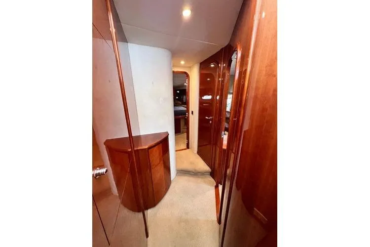 Slide: The Image of 2003 Viking Princess 50 Sport Cruiser interior hallway with wooden cabinetry and soft lighting. - 27