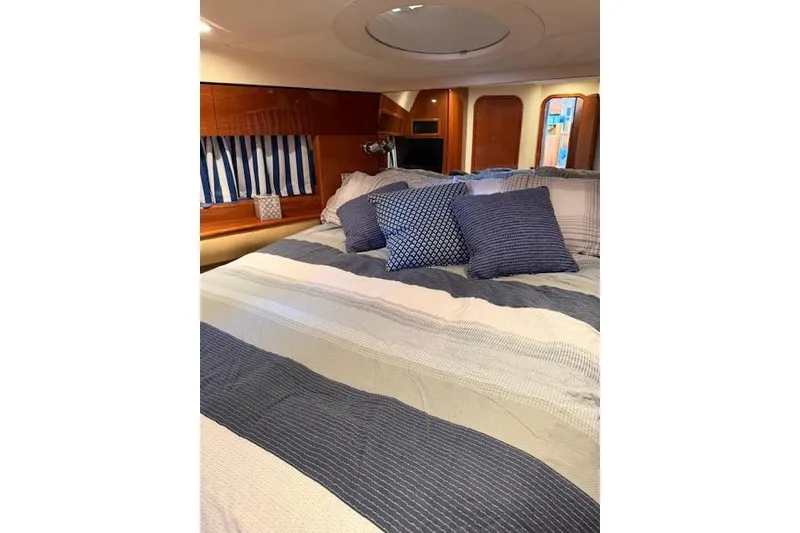 Slide: The Image of Luxurious cabin interior of 2003 Viking Princess 50 Sport Cruiser with striped bedding. - 4