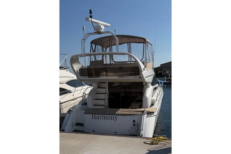 Slide: The Image of 2003 Viking Princess 50 Sport Cruiser docked, rear view with canopy and "Harmony" name. - 5