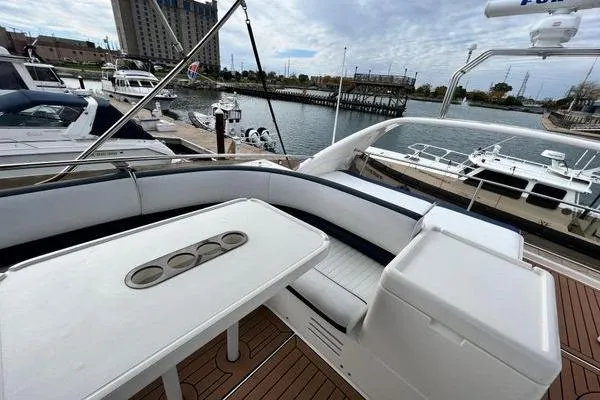 Slide: The Image of 2003 Viking Princess 50 Sport Cruiser yacht with spacious deck and seating area at marina. - 8