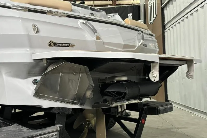 Slide: The Image of 2024 MasterCraft X24 boat rear view with supercharged engine detail in a garage setting. - 16