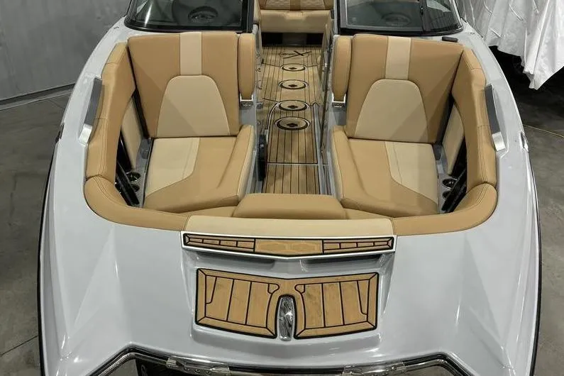 Slide: The Image of 2024 MasterCraft X24 boat interior with tan seating and wooden flooring. - 4