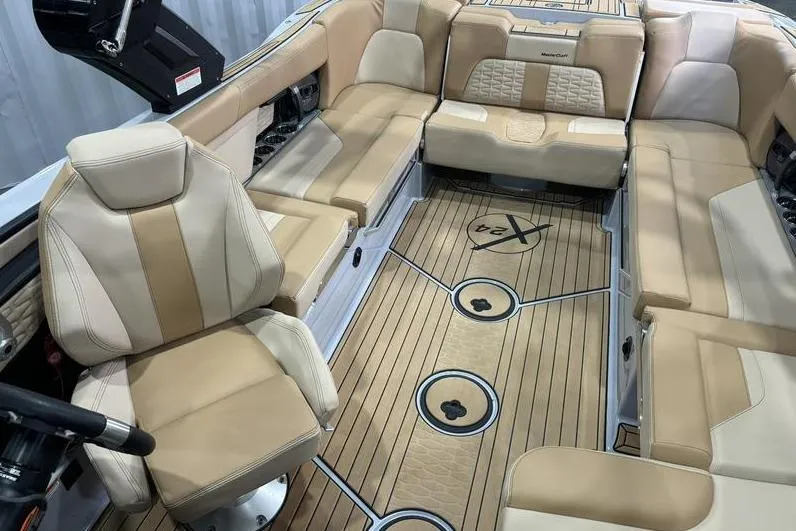 Slide: The Image of 2024 MasterCraft X24 boat interior with beige seating and stylish wood flooring. - 8