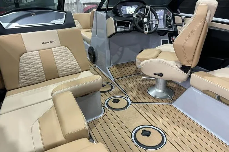 Slide: The Image of 2024 MasterCraft X24 boat interior with beige seating and modern dashboard. - 9