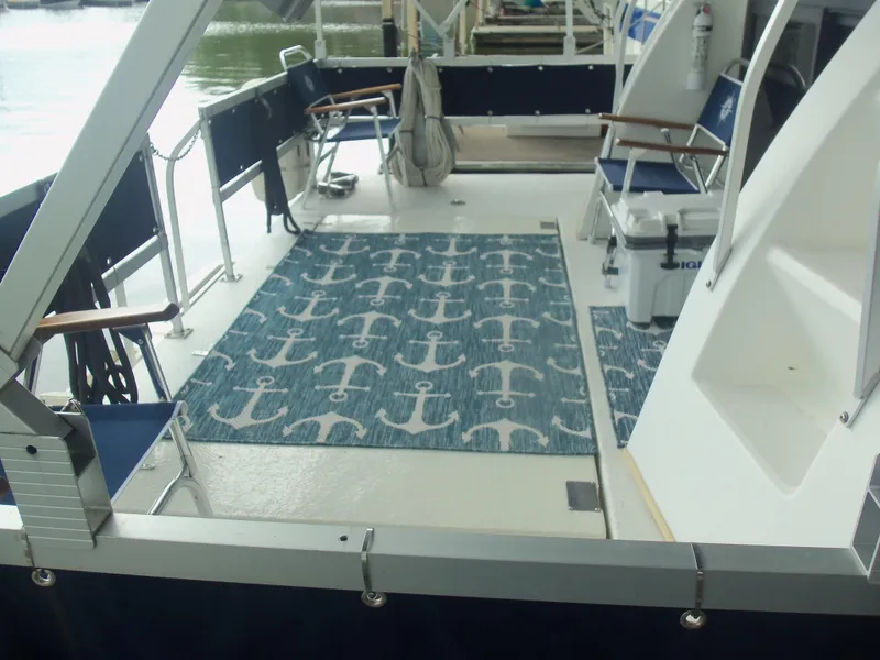 Slide: The Image of 2003 Gibson Classic boat deck with anchor-patterned rug and seating area. - 10