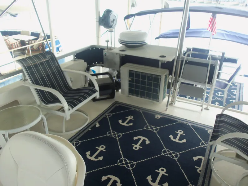Slide: The Image of Boat deck with nautical-themed decor, featuring anchor-patterned rug and striped chairs. - 18
