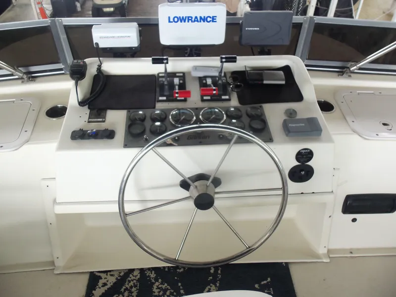 Slide: The Image of Helm of 2003 Gibson Classic boat with steering wheel and navigation equipment. - 19