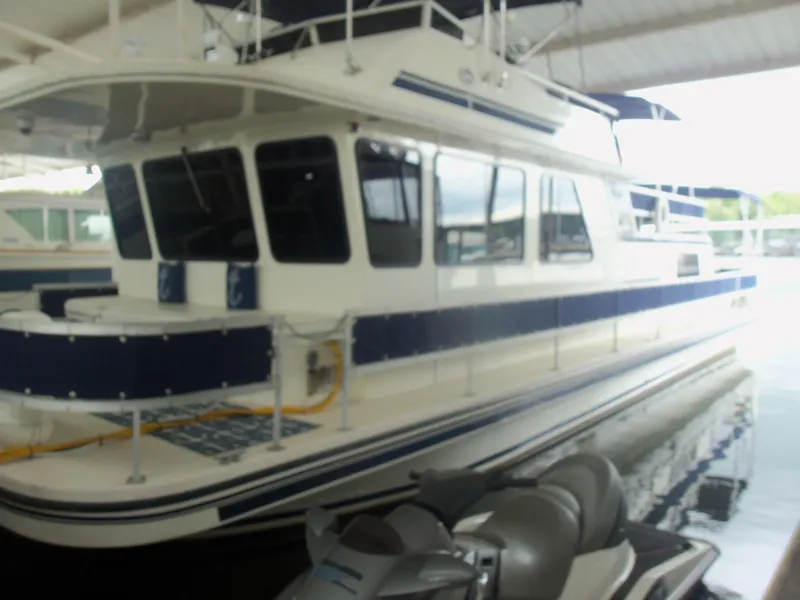 Slide: The Image of 2003 Gibson Classic houseboat docked in a covered marina. - 2