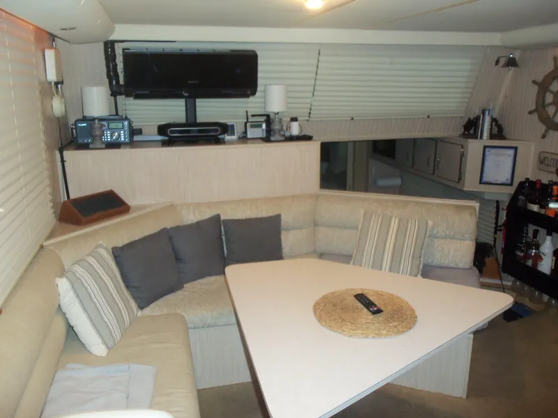 Slide: The Image of Cozy boat interior with beige seating, triangular table, and entertainment setup, Gibson Classic 2003. - 27