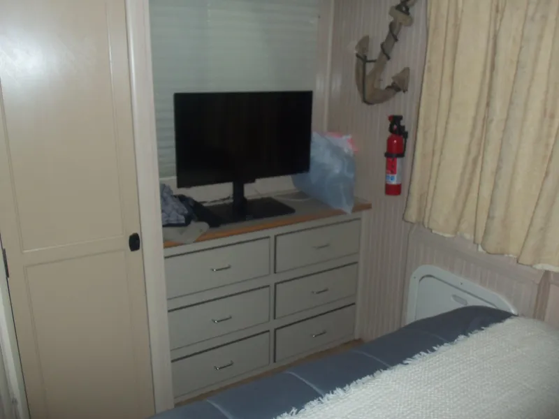 Slide: The Image of Cozy room with TV, dresser, and fire extinguisher, featuring a nautical anchor decor. - 40