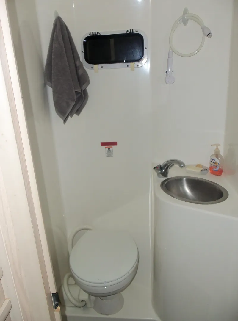 Slide: The Image of Compact bathroom in a 2003 Gibson Classic boat with toilet, sink, and towel. - 44