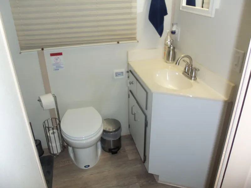 Slide: The Image of Compact bathroom with toilet, sink, and storage cabinet, featuring modern fixtures and neutral decor. - 48