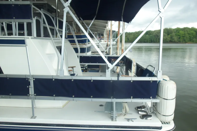 Slide: The Image of 2003 Gibson Classic boat docked on a calm lake with canopy and railing. - 6