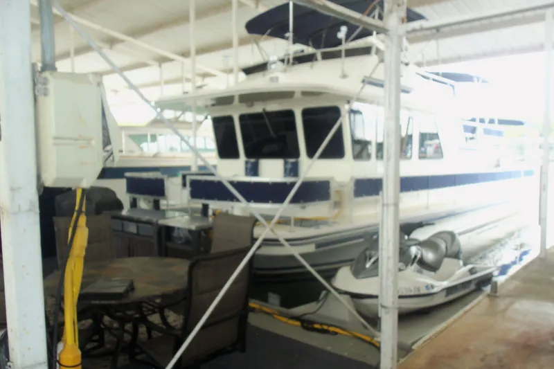 Slide: The Image of Houseboat docked in marina with outdoor seating, featuring a 2003 Gibson Classic model. - 7