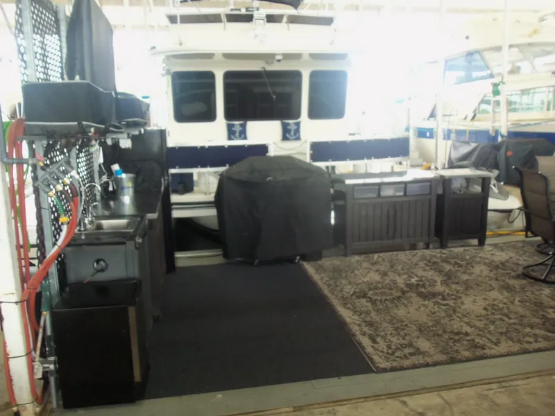 Slide: The Image of Outdoor kitchen setup on a 2003 Gibson Classic boat with sink, grill, and seating area. - 8