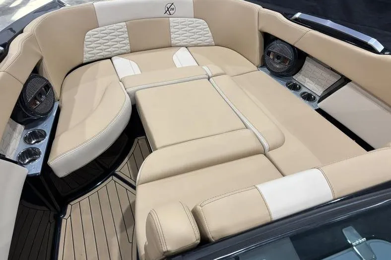 Slide: The Image of 2024 MasterCraft X26 boat interior with luxurious beige seating and cup holders. - 6