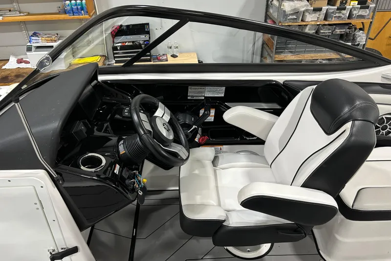 Slide: The Image of 2019 Yamaha Boats 212X cockpit with steering wheel and white captain's chair. - 15