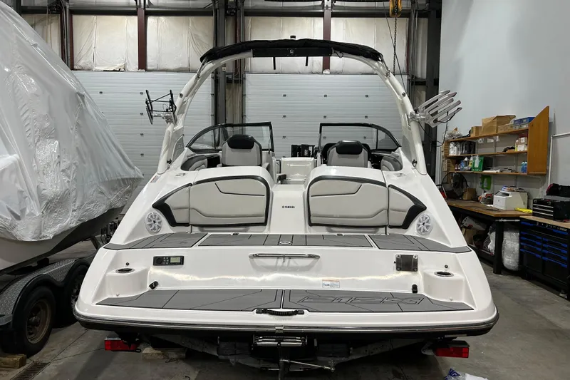 Slide: The Image of 2019 Yamaha Boats 212X in a garage, showcasing rear seating and swim platform. - 5