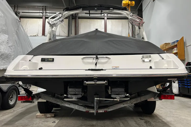 Slide: The Image of 2019 Yamaha Boats 212X in storage, rear view with cover, indoor setting. - 9
