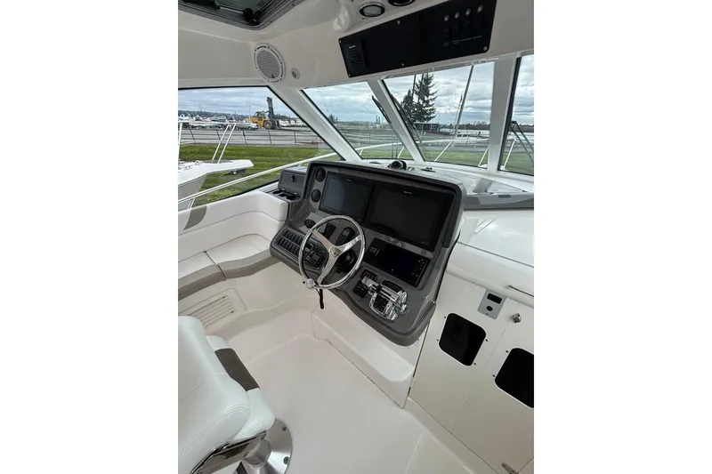 Slide: The Image of Triple outboard motors on a 2010 Boston Whaler 345 Conquest, resting on gravel. - 12