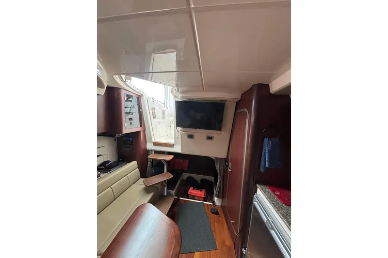 Slide: The Image of Interior of 2010 Boston Whaler 345 Conquest, featuring seating, table, and TV. - 53