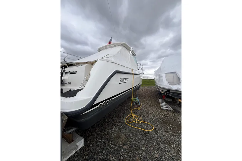 Slide: The Image of 2010 Boston Whaler 345 Conquest boat on land, under cloudy skies. - 55