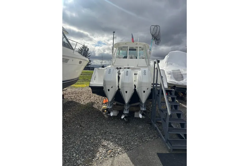 Slide: The Image of 2010 Boston Whaler 345 Conquest boat with American flag, enclosed cockpit, and overcast sky. - 6
