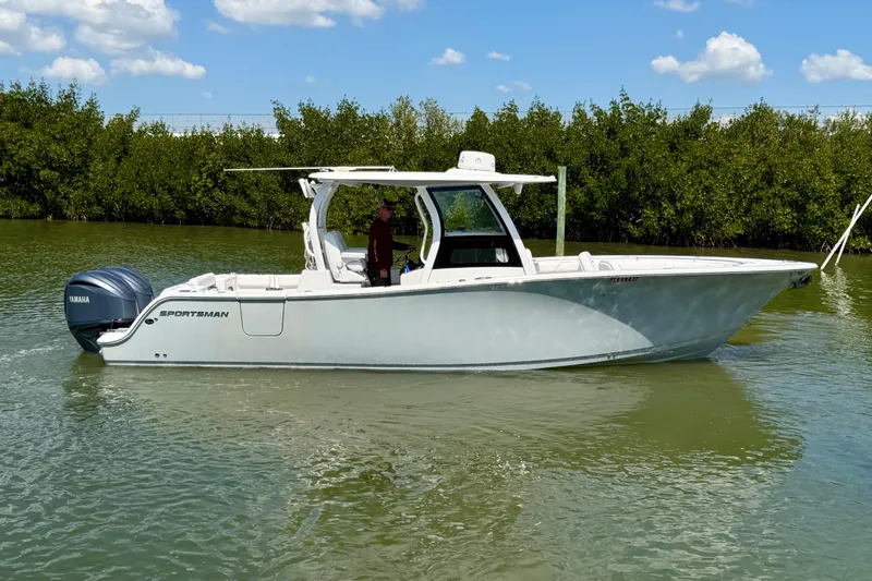 The Image of 2021 Sportsman Open 302 Center Console boat on calm water, side view. - 0