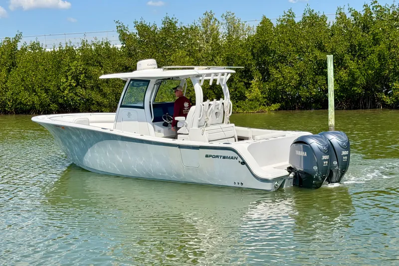 Slide: The Image of 2021 Sportsman Open 302 Center Console boat on calm water with twin Yamaha engines. - 2