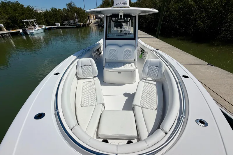 Slide: The Image of 2021 Sportsman Open 302 Center Console boat with luxurious seating at a dock. - 6