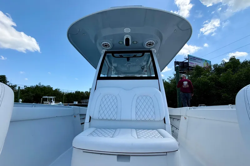 Slide: The Image of 2021 Sportsman Open 302 Center Console boat with white seating under a clear blue sky. - 7