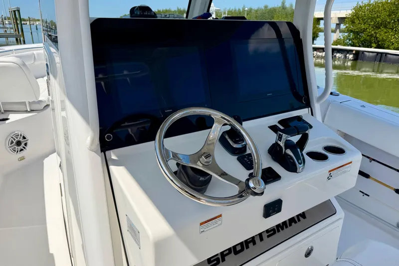 Slide: The Image of 2021 Sportsman Open 302 Center Console boat helm with steering wheel and controls. - 9