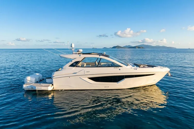 The Image of 2021 Cruisers Yachts 42 GLS OB on serene ocean with distant islands. - 1