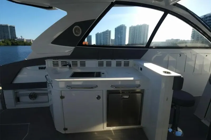 Slide: The Image of 2021 Cruisers Yachts 42 GLS OB interior with modern kitchenette and cityscape view. - 18
