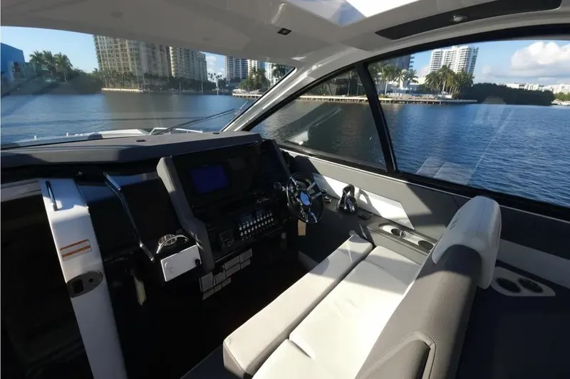 Slide: The Image of Interior view of 2021 Cruisers Yachts 42 GLS OB helm with waterfront backdrop. - 19