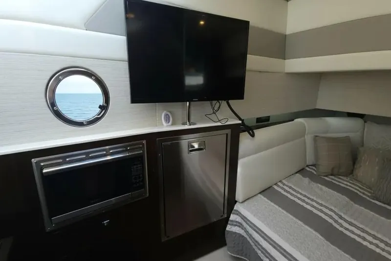 Slide: The Image of Interior of 2021 Cruisers Yachts 42 GLS OB with TV, porthole, and cozy seating area. - 27